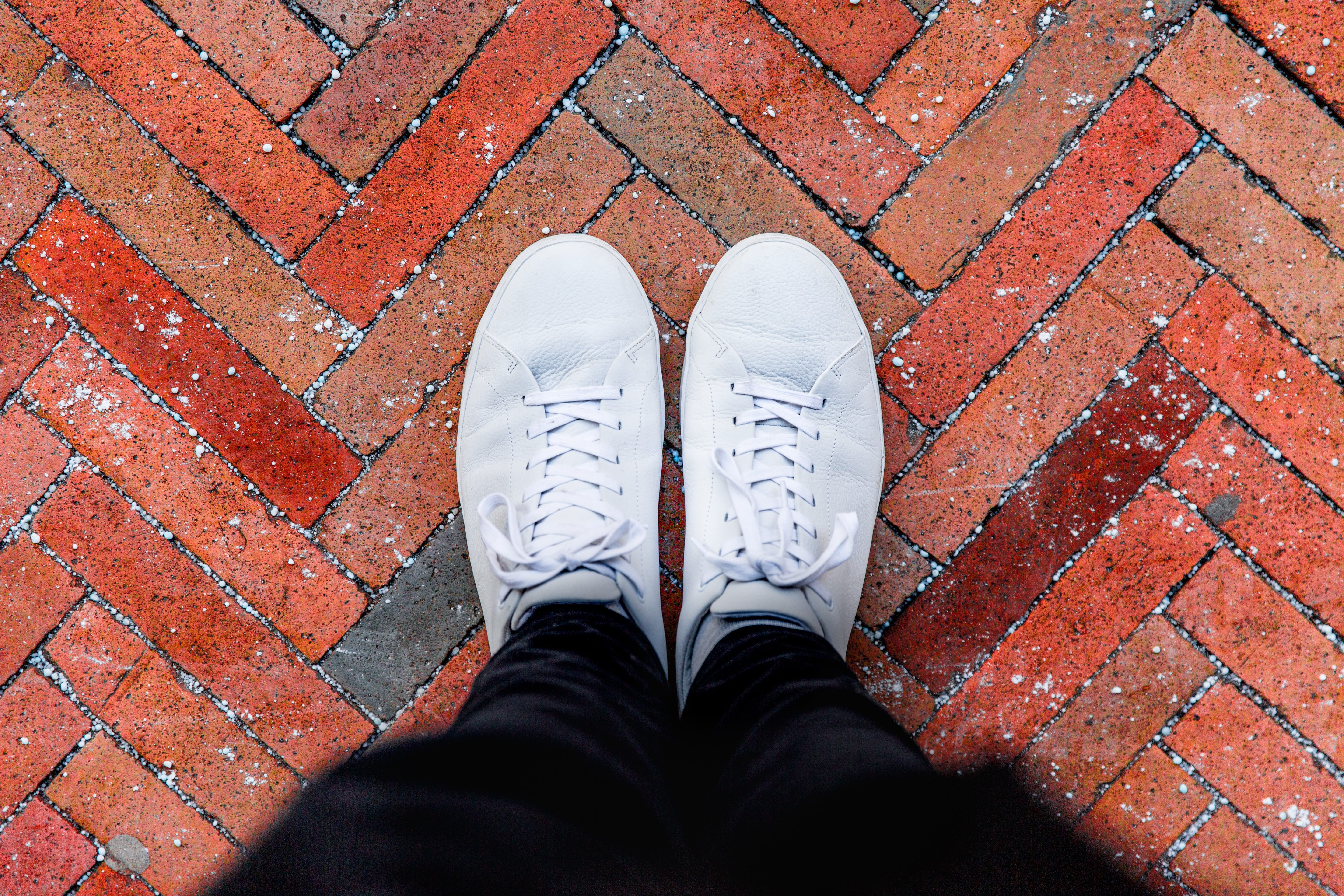 standing with white walking shoes on red brick
