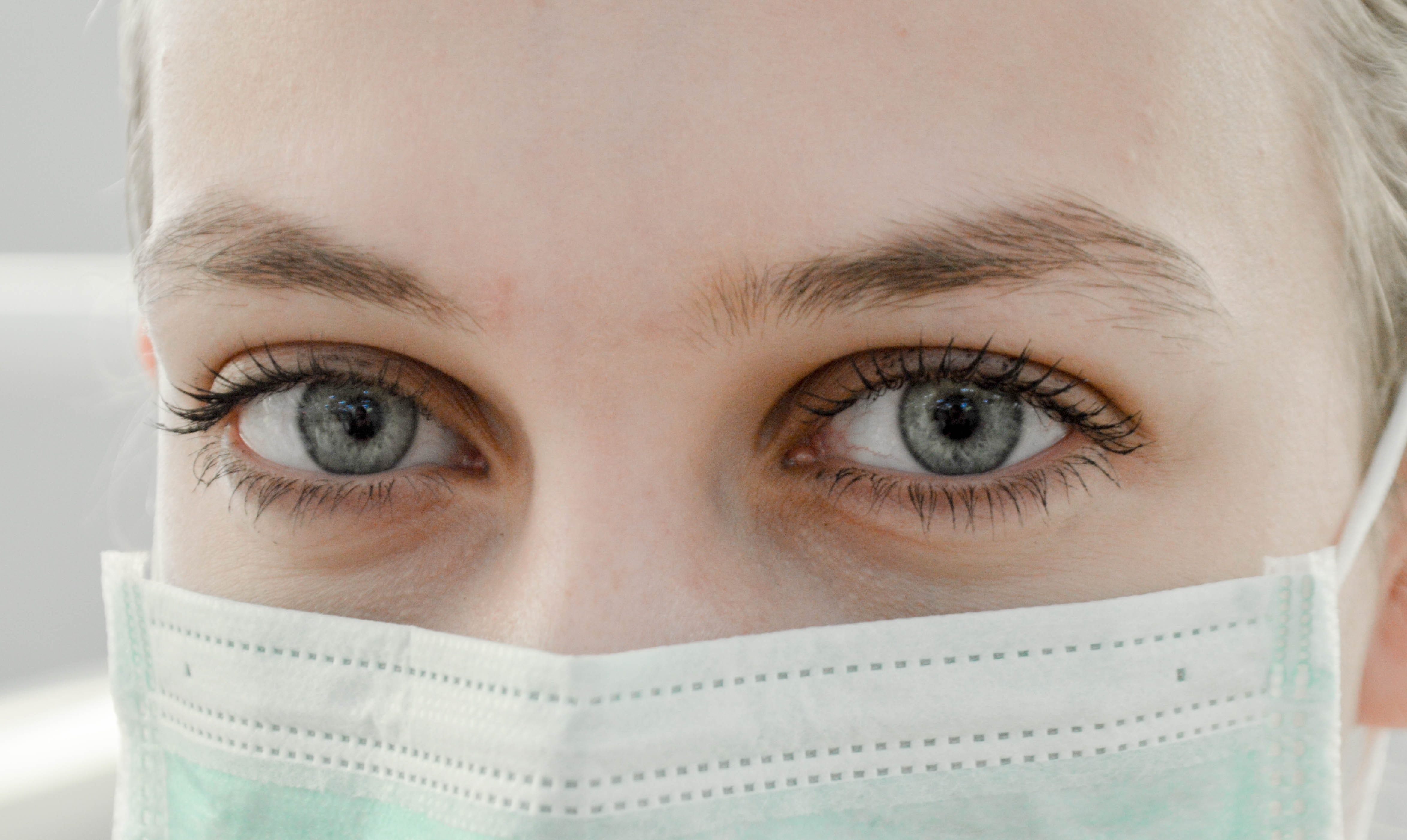 close up of blonde woman wearing surgical mask